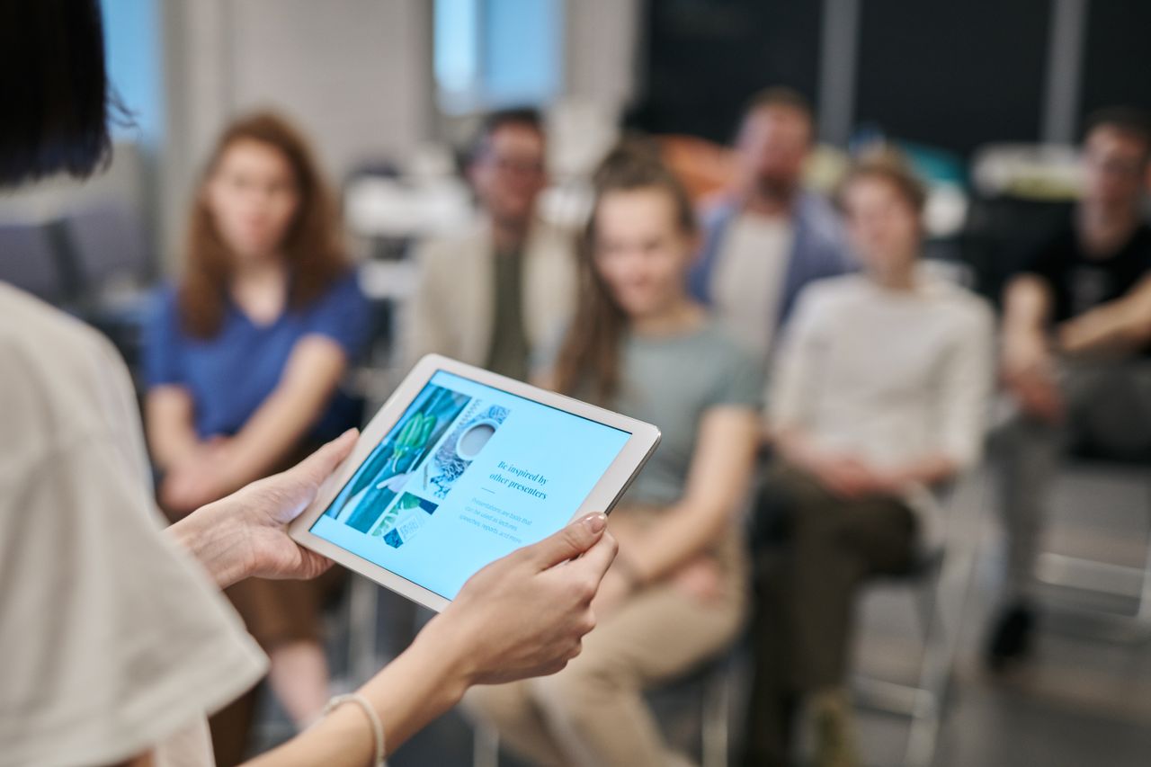 Mastering the First Impression: Your intriguing post title goes here Business seminar with participants focused on a tablet presentation in an office setting.
